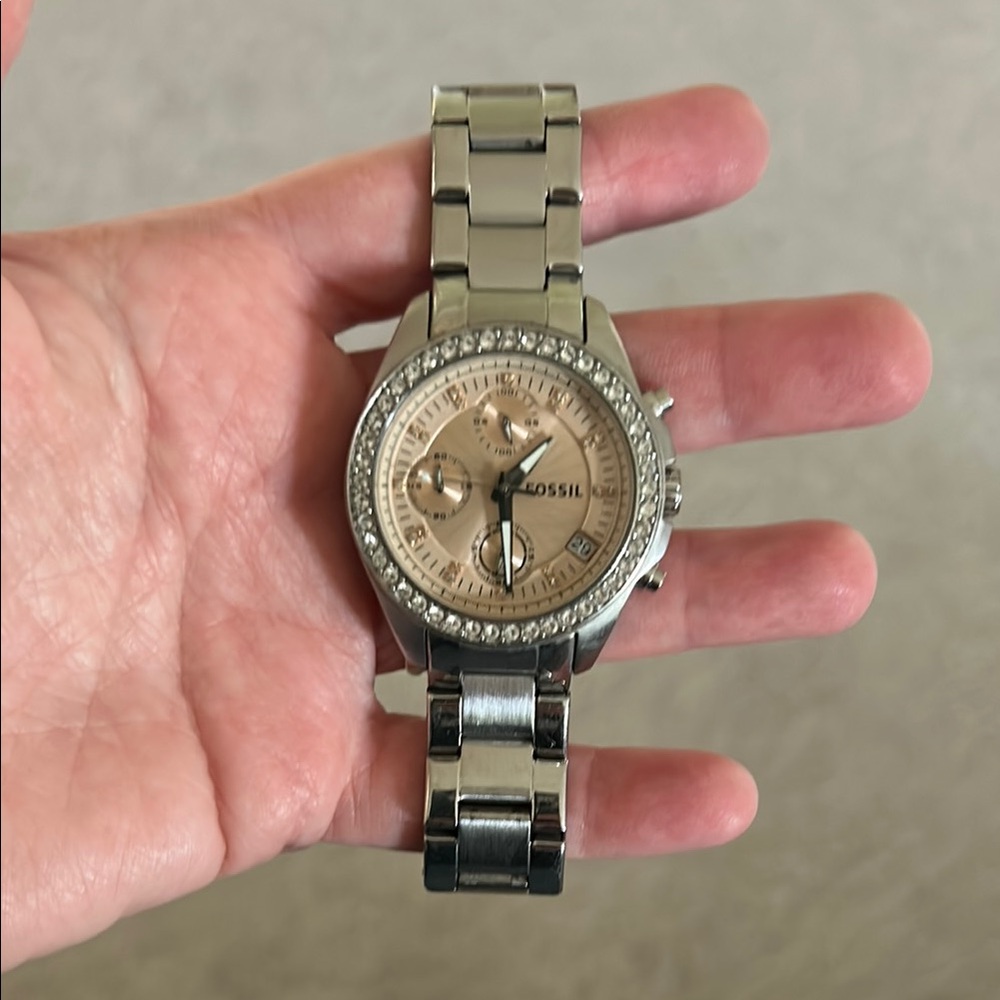 Fossil Silver watch with rose gold face and clear stone inlay.